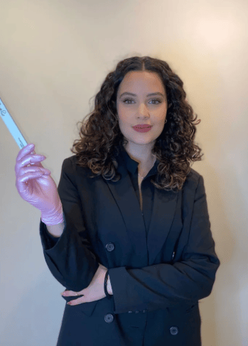 a woman in a black suit and gloves holding a toothbrush