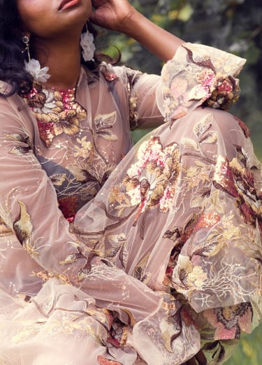 Une femme vêtue d’une robe à fleurs Anaïs Ricard assise sur une chaise 