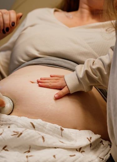 Kinderhand op blote buik van zwangere vrouw