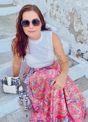 a woman in a white tank top and pink skirt