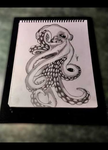 Boceto de pulpo dibujado a mano con carbón en un cuaderno de dibujo en espiral, con tentáculos.