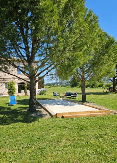 Vue sur la maison d'hôtes la Ramade et son terrain de pétanque.