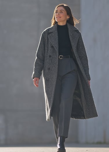 a woman in a coat and a coat over a black coat