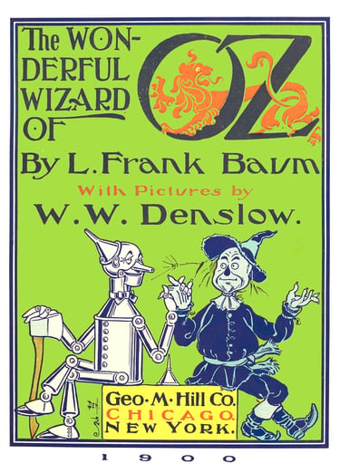 Vintage first edition book cover of The Wonderful Wizard of Oz by L. Frank Baum featuring the Tin Man and Scarecrow.