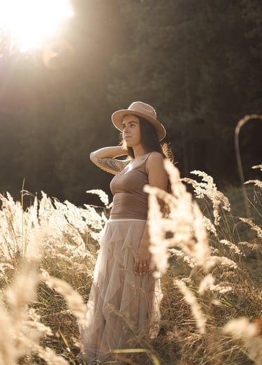 Woman standing on the field during sunset