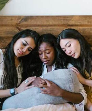 Friends comforting a woman in distress, showing care and support.