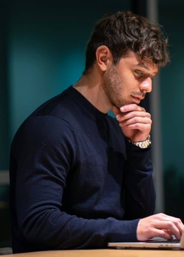 a man sitting at a desk with a laptop computer