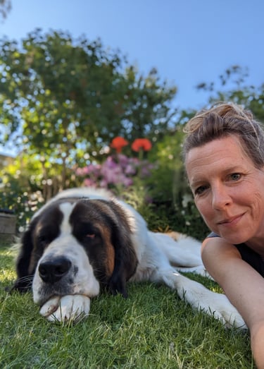 Hund und Mensch auf einer Wiese liegend