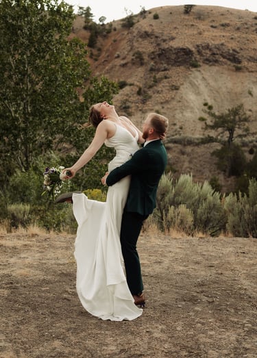 a bride and groom are posing for a photo, groom is holding the bride and spinning