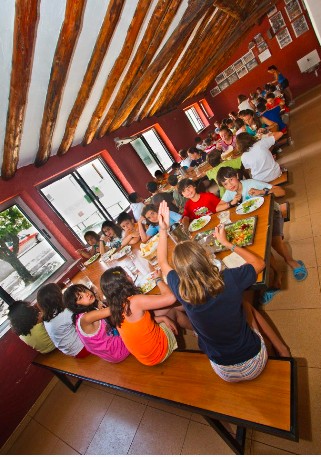 niños comiendo en el comedor del campamento