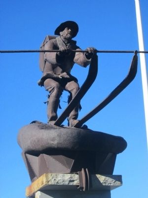 a sculpture of a man skiing wearing a hat and pack