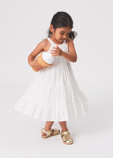 Fashion photography - a young girl in a white dress holding an icecream