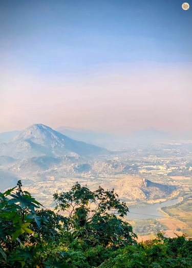 View of Skandagiri peak from the Gandhi Nilaya viewpoint at Nandi Hills, overlooking misty valleys and surrounding hills