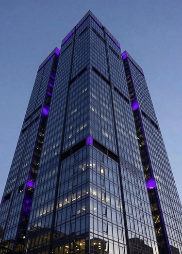 A low-angle shot of a sleek, dark glass skyscraper in a North American city at dusk. The building is illuminated with deep purple accents, conveying a sophisticated and professional corporate media presence.