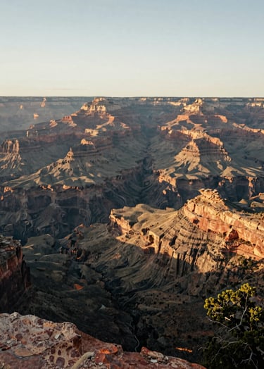 A breathtaking wide-angle landscape of a North American / US canyon at dawn. The light is a Soft Off-white glow hitting the Charcoal Gray rock faces. A serene and professional travel photograph with Warm Olive tones in the vegetation.