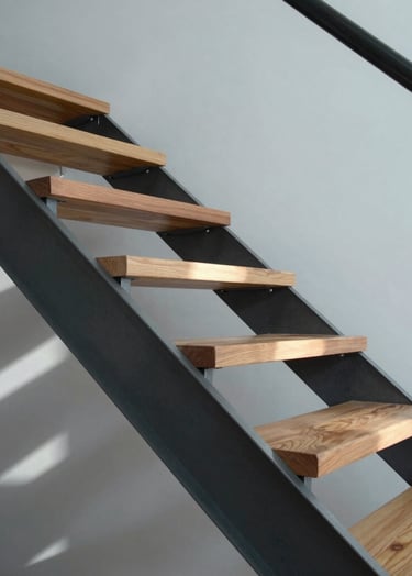 Close-up of a custom wood and steel staircase inside a minimalist house, precise joints, architectural detail, lighting casting linear shadows, slate grey and pale blue-grey palette.