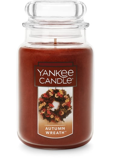 Large amber candle jar labeled Autumn Wreath, fall-inspired scent.