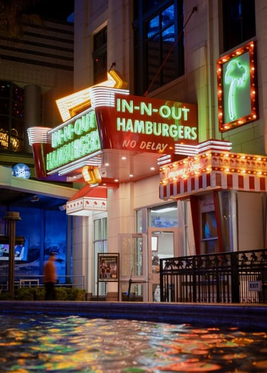 Super colorful photo of In-n-Out Hamburgers, neon lights reflecting off fountain water.