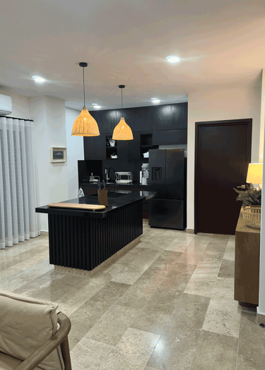 Diseño contemporáneo en cocina con isla central, iluminación cálida y acabados en negro | KARÄNA