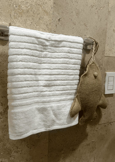 Decoración costera con textura suave y acento artesanal en baño con muros de piedra natural | KARÄNA