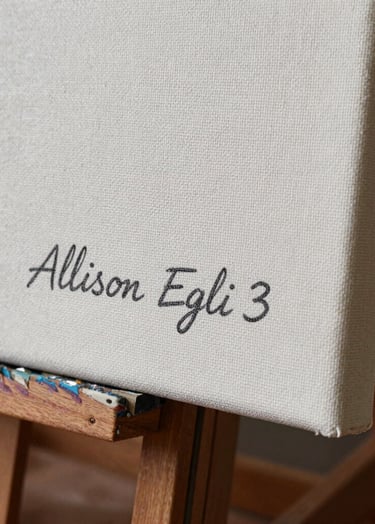 A detailed, sharp photograph of the bottom corner of a professional art canvas. The name 'Allison Egli' is subtly inscribed in charcoal paint. The fine weave of the canvas is visible under professional studio lighting.