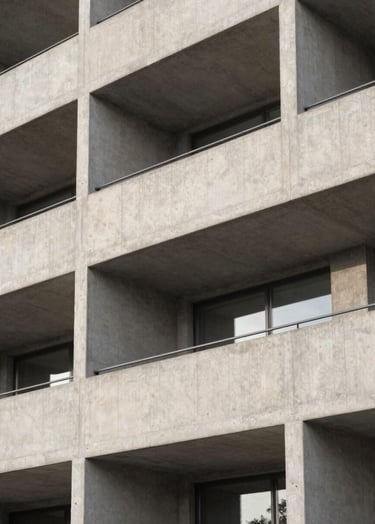 A minimalist architectural photograph of a brutalist concrete building facade in Copenhagen, soft morning light, monochromatic tones of off-white and medium gray, clean sharp lines, North American / European.