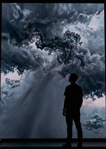 Silhouette of a creative director standing in front of a massive LED volume screen displaying a stormy sky in steel smoke and midnight slate. High impact, cinematic lighting.