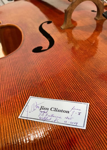 Cello top plate with Jim Clinton label laying on top before installation