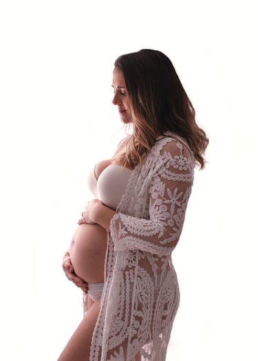 a pregnant woman in a white lace robe and a white robe