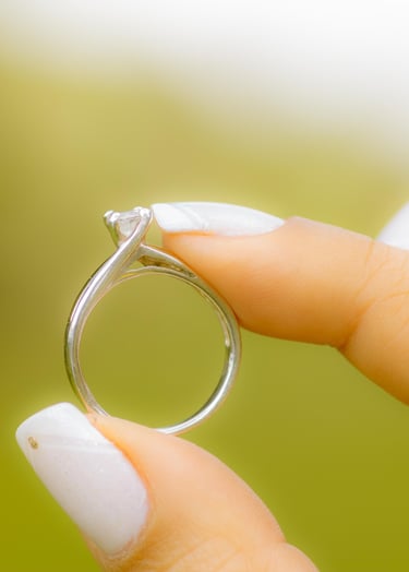 Hermoso anillo de compromiso sostenido por la novia con sus dedos  pulgar e indice. 