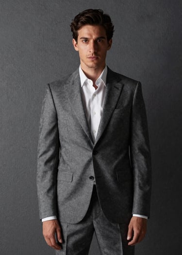 Retrato de alta gama de una persona con traje a medida contra una pared gris oscuro texturizada, luz lateral suave creando sombras dramáticas, estilo elegante del sur de Europa.