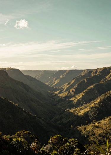 A wide-angle cinematic shot of the lush, mountainous Vale do Aço landscape in Brazil during the golden hour. The sky is a mix of pearl white and soft sage green. The composition is atmospheric and professional, showcasing the natural beauty of the South American / Brazilian environment.