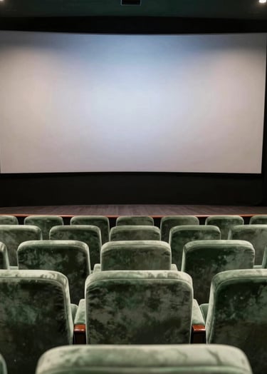 A cinematic wide shot of a South American / Brazilian theater interior with muted sage green velvet seats, a large silver screen glowing with light, creating a sophisticated and artistic atmosphere in a dark forest green environment.