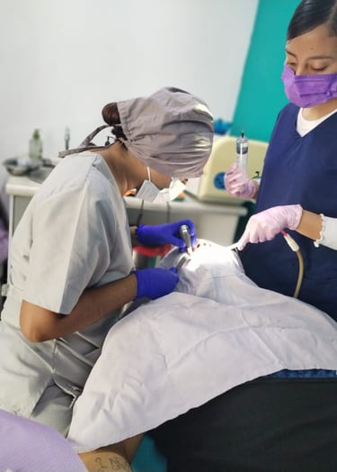 Dos dentistas profesionales atendiendo a paciente en consultorio dental
