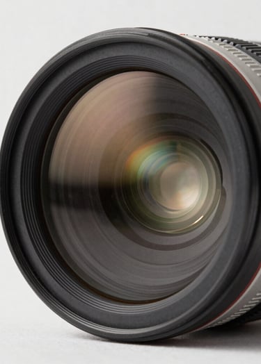 A professional camera lens reflecting a bright minimalist studio. The composition is a sharp close-up on glass and metal textures. The color palette includes charcoal, silver, and off-white. International / Professional.