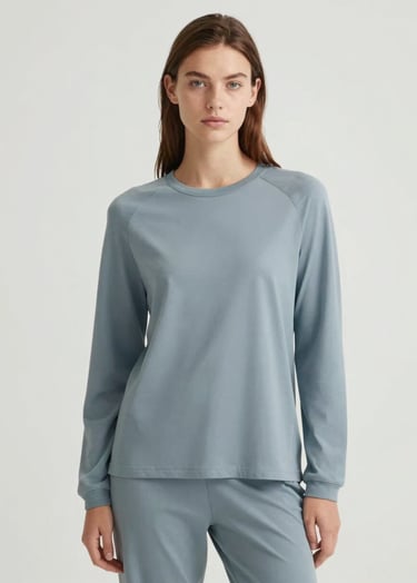 A fashion-forward model with an authentic look posing for a digital campaign. The style is Scandinavian chic, with minimalist clothing in shades of #74A8AE. Professional studio lighting with a clean #ECF3F4 background.