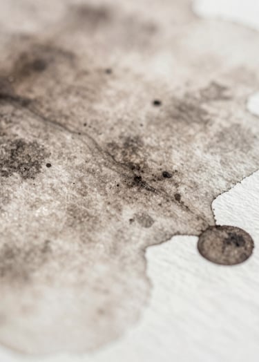 A macro photograph of watercolor pigments bleeding into water on paper, abstract and inspiring, showing the soft beauty of color movement in shades of #6F5E52 and #F5F2EF.