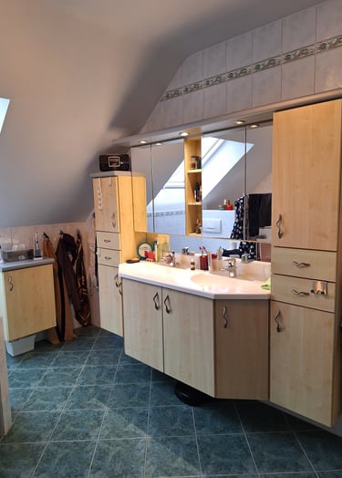 Salle de bain avant rénovation avec un meuble suspendu sur-mesure et deux grands miroirs