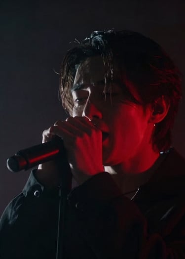 Moody music video scene, singer performing under a sharp red backlight in a dark smoky studio, extreme close-up