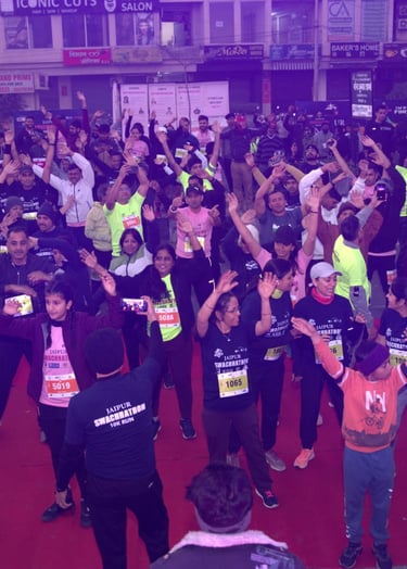 A large group of runners doing warm-up exercises at the Jaipur Ultra 10K run event.