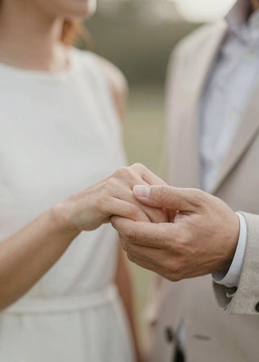 A close-up shot of a couple's hands during an engagement session, capturing an intimate moment of connection. Soft, warm natural lighting with a palette of #CFC7BB and #F7F5F0, reflecting an artistic and elegant mood.