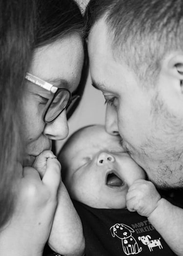 Deux parents faisant un bisou à leur bébé