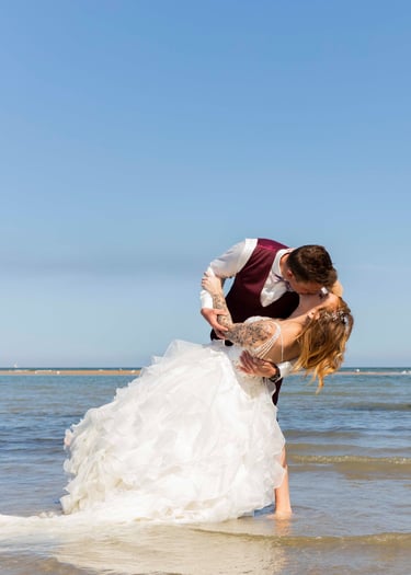 Couple fraîchement marié s'embrasse à la plage