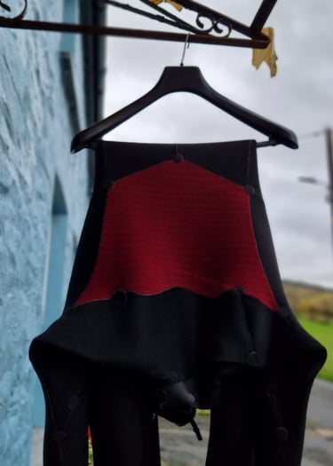 A wetsuit hanging up to dry on a clothes hanger