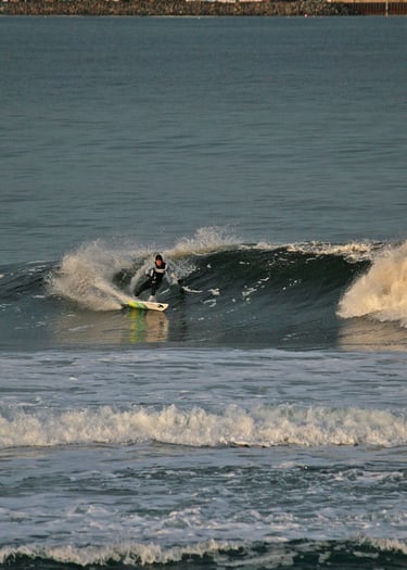 A surfer doing a forehand cutback in the early morning sun.