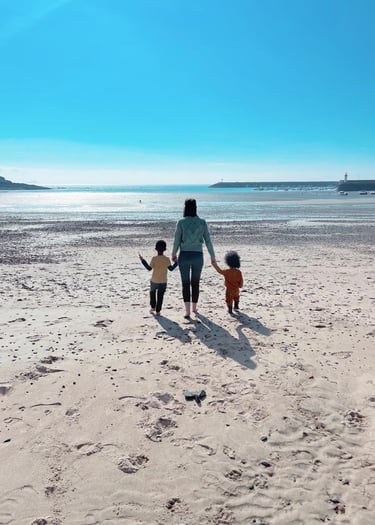a woman and two children walking on a beach