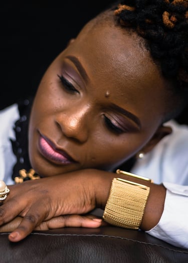 A Black woman resting peacefully with her head on her arm, symbolizing sacred rest....