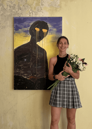 an artist in exhibition standing next to her painting holding flowers