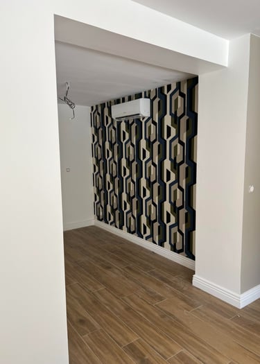 a room with a wallpapered wall and a wooden floor