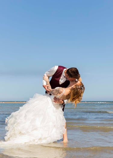 Couple fraîchement marié s'embrasse à la plage